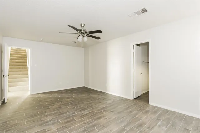 a view of a big room with wooden floor and windows