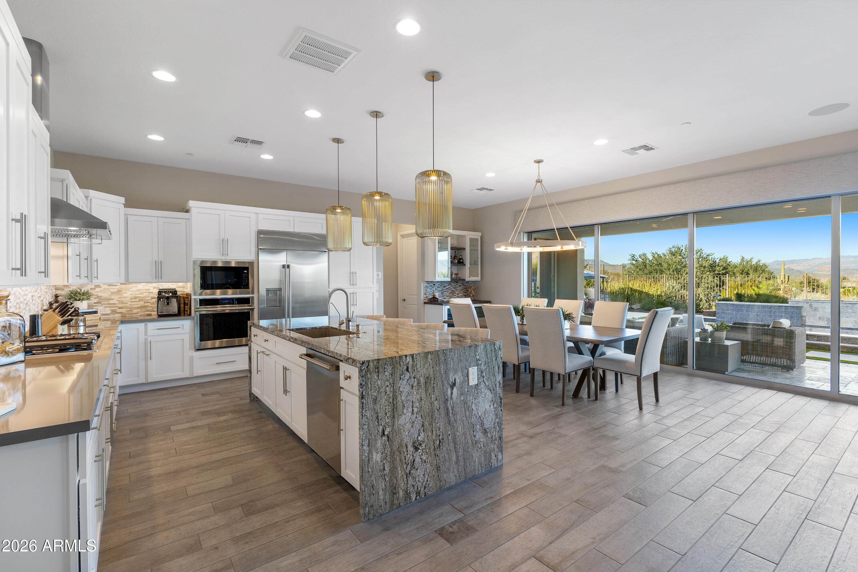 28803 North Sandal Court Rio Verde, AZ 85263 - Photo 9 of 85 a large kitchen with kitchen island a large island a sink a stove and a view of living room next to a large window