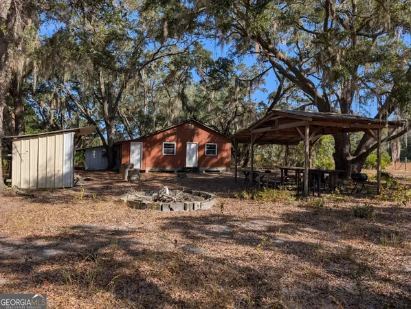 a backyard of a house with lots of plants and wooden fence