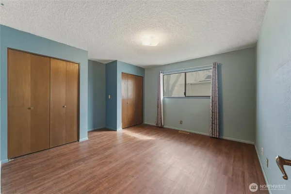 an empty room with wooden floor and closet