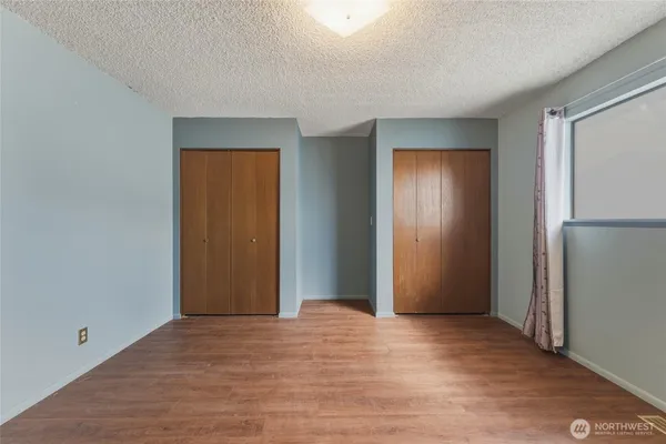 a view of an empty room with closet and a window