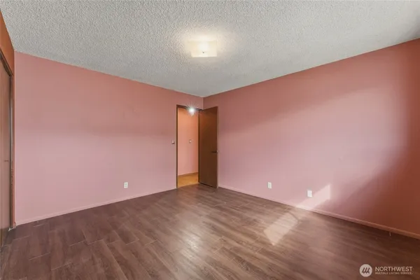 a view of an empty room with wooden floor