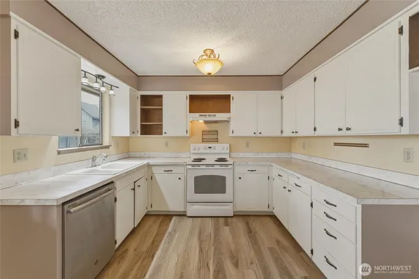 a kitchen with a sink stove and cabinets