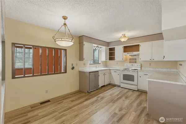 a kitchen with granite countertop white cabinets and white appliances