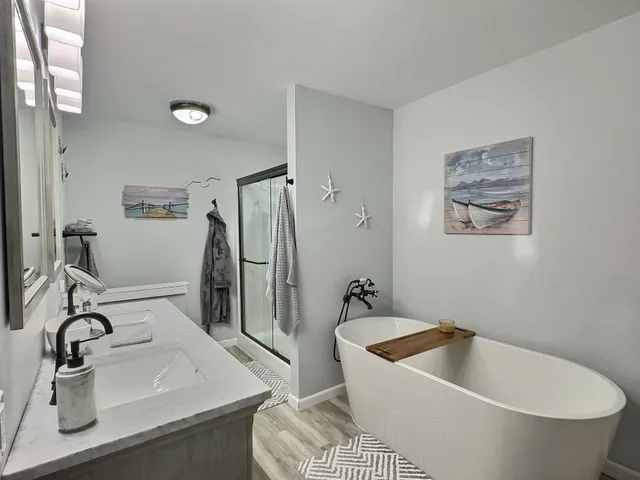 a bathroom with a tub sink and mirror