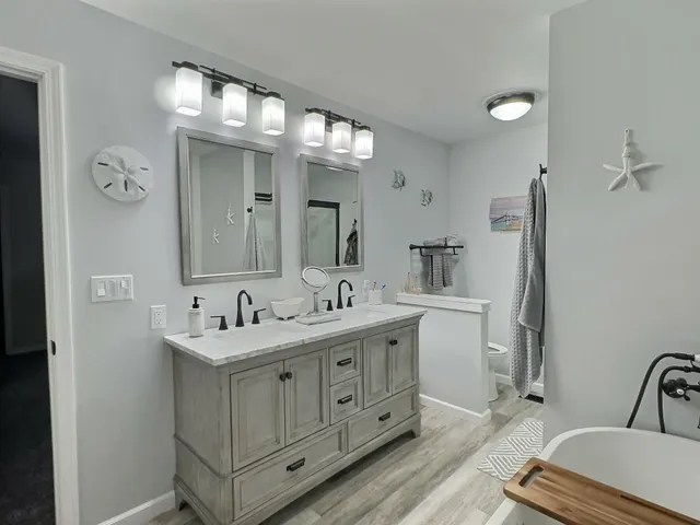 a white bath tub sitting next to a bathroom sink