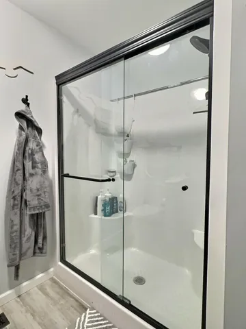 a bathroom with double vanity sink a mirror and a shower