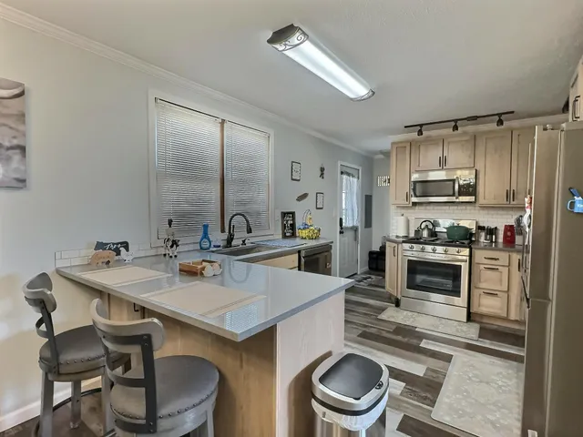 a kitchen with granite countertop a refrigerator stove and microwave