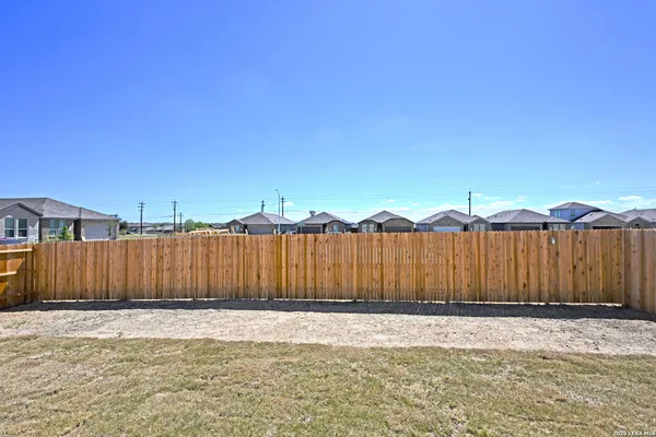 a view of a backyard with wooden fence