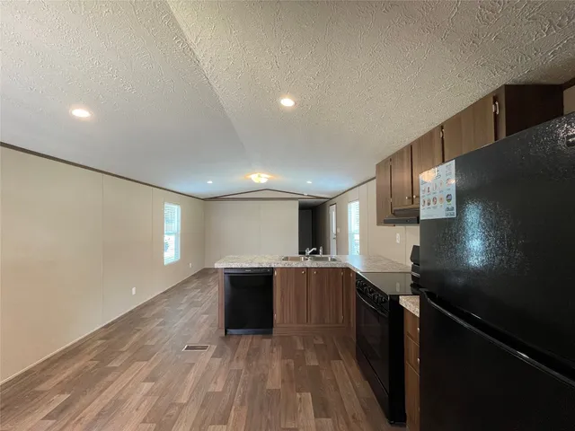 a kitchen with granite countertop a sink and cabinets