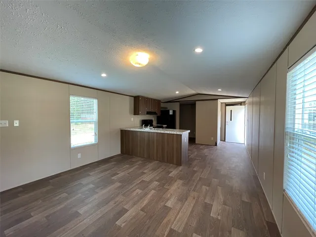 a view of a big room with wooden floor and windows
