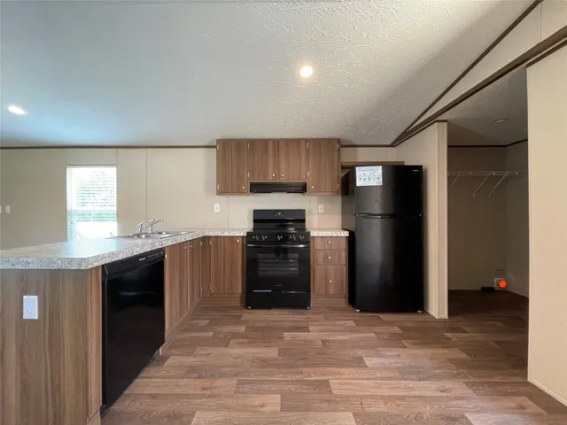 a kitchen with a refrigerator and a stove top oven