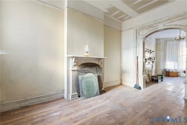 a view of a livingroom with wooden floor and staircase