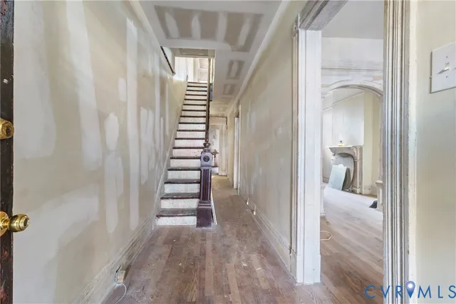 a view of a hallway with wooden floor and staircase