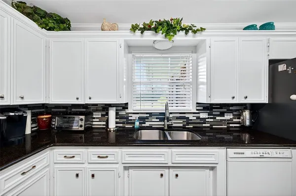 a kitchen with white cabinets and appliances