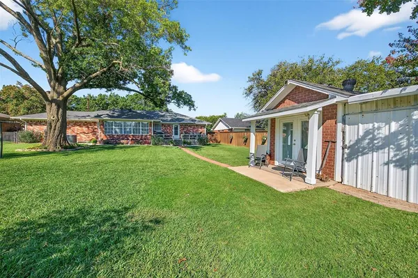 a view of a house with backyard and sitting area