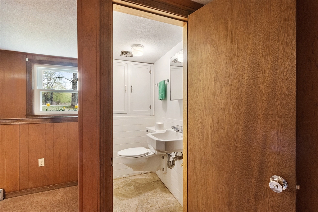 69 Little Turnpike Road Shirley, MA 01464 - Photo 32 of 37 a bathroom with a granite countertop sink a toilet and a mirror
