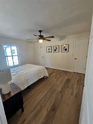 a bedroom with a bed chandelier and a window
