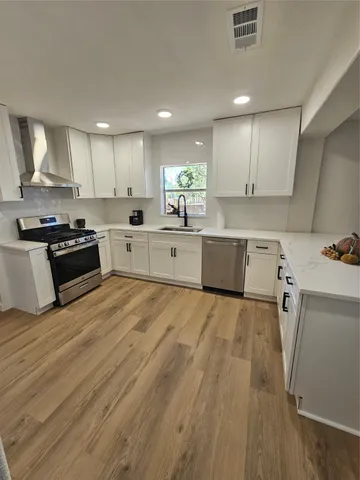 a kitchen with stainless steel appliances a refrigerator sink and cabinets