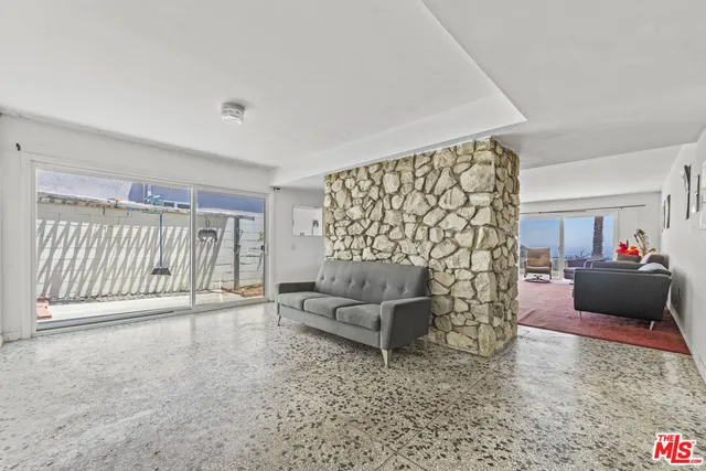 a living room with furniture and a floor to ceiling window