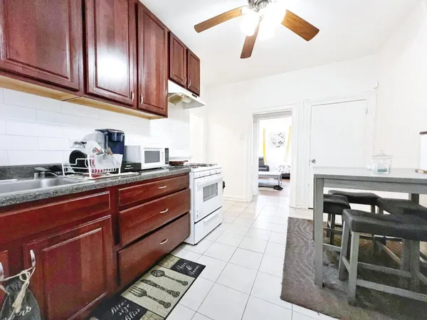 a kitchen with stainless steel appliances granite countertop a stove a sink and a microwave