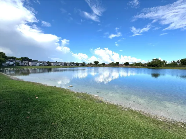 an aerial view of residential houses with outdoor space and lake view