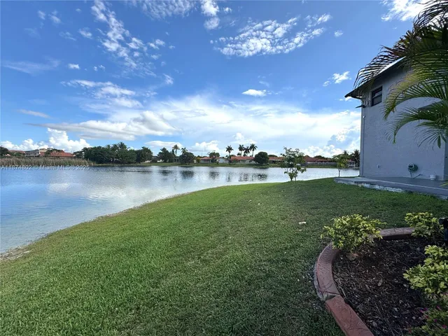 an aerial view of a house with swimming pool and outdoor seating