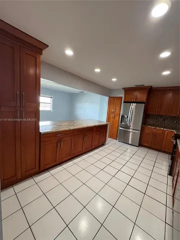 a large kitchen with kitchen island a sink a counter space and living room view