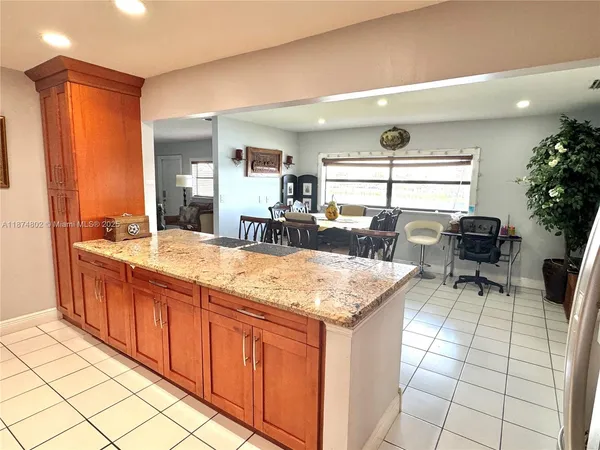 a kitchen with stainless steel appliances kitchen island granite countertop a sink and cabinets