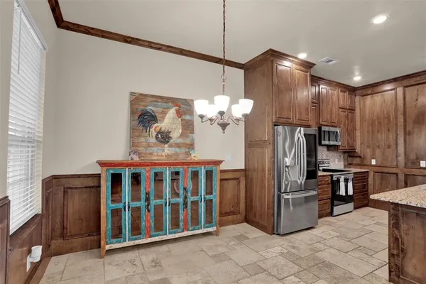 a kitchen with stainless steel appliances kitchen island granite countertop a refrigerator a stove a microwave oven a sink with island and chairs