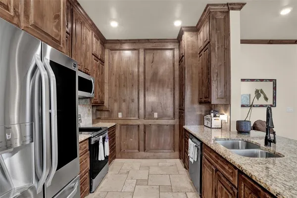 a kitchen with stainless steel appliances granite countertop a refrigerator and a sink