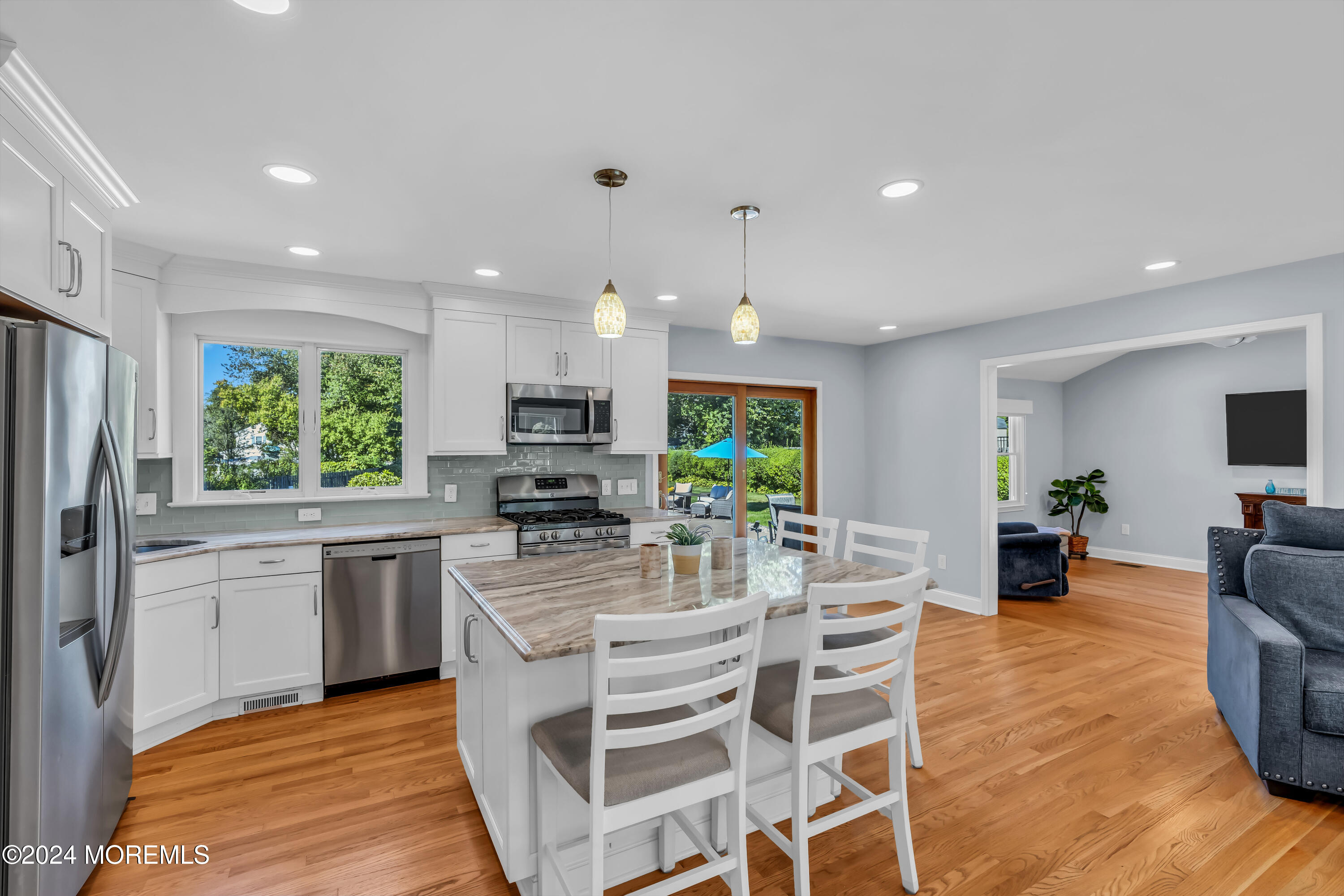 111 Remsen Mill Road Neptune Township, NJ 07753 - Photo 12 of 80 a kitchen with stainless steel appliances kitchen island granite countertop a stove top oven a sink dishwasher a dining table and chairs with wooden floor