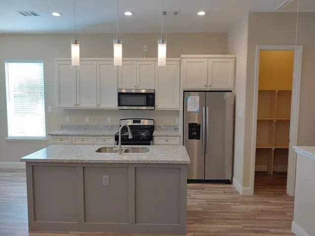 a kitchen with white cabinets and stainless steel appliances