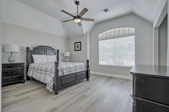 a spacious bedroom with a bed and a chandelier