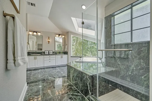 a bathroom with a granite countertop sink and a large mirror