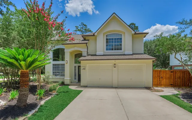 a view of a house with a small yard and wooden fence