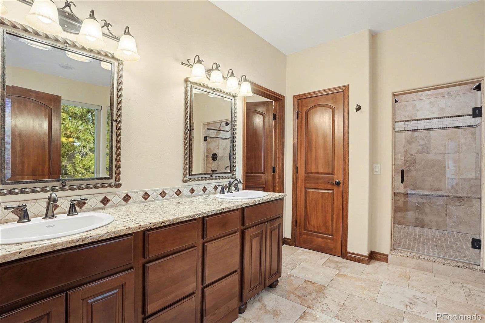 7936 Monarch Road Larkspur, CO 80118 - Photo 12 of 24 a bathroom with double vanity sinks and a mirror
