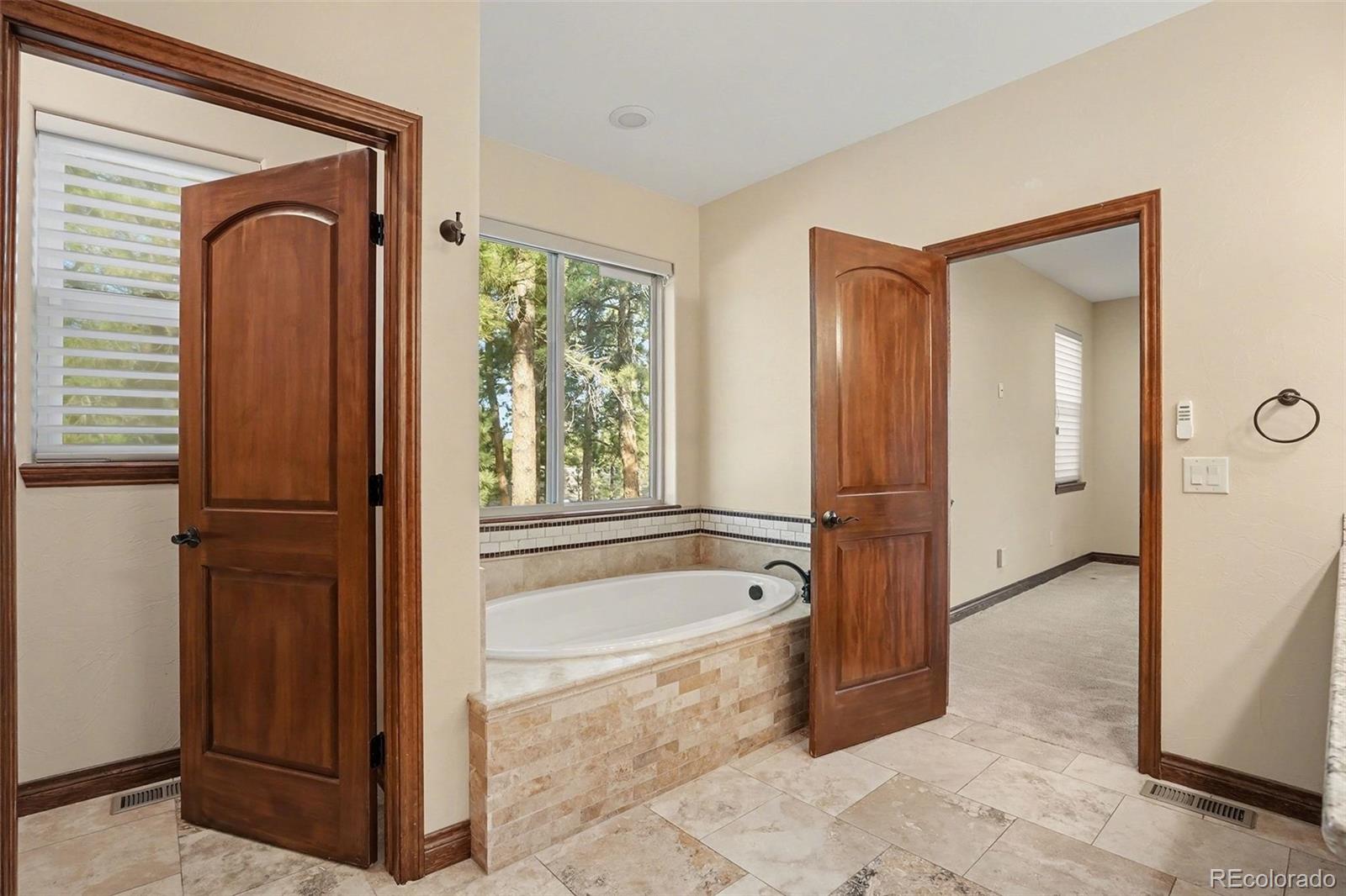7936 Monarch Road Larkspur, CO 80118 - Photo 13 of 24 a bathroom with a tub shower and sink