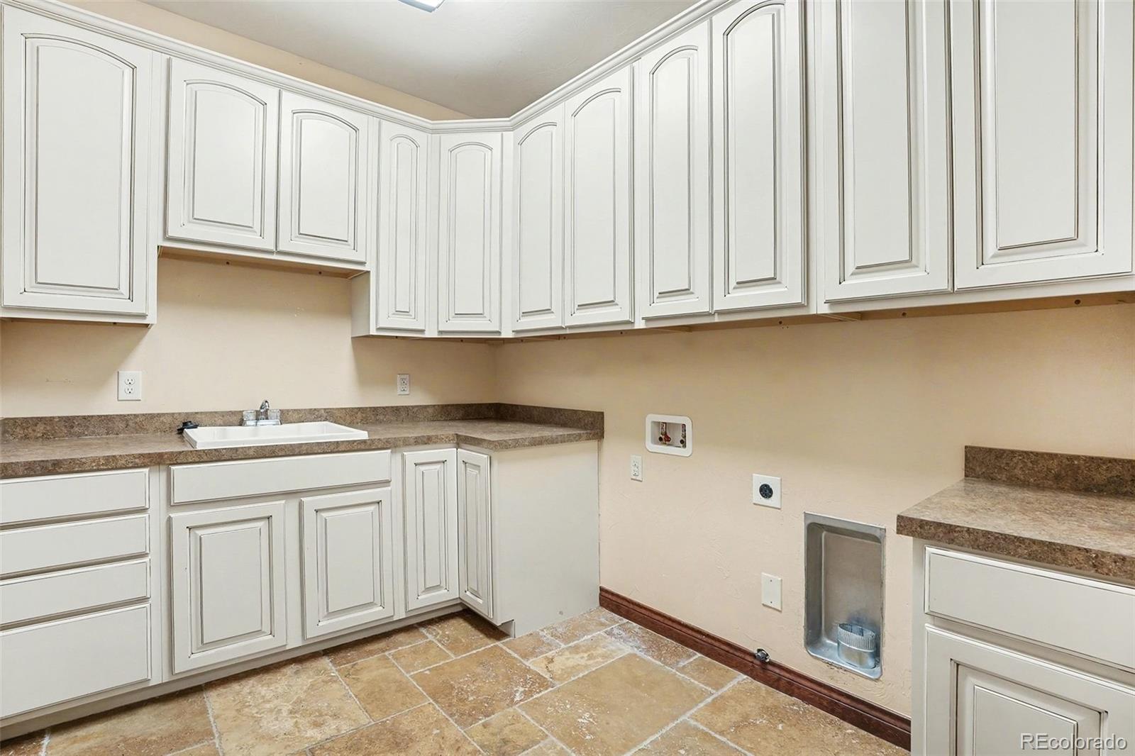 7936 Monarch Road Larkspur, CO 80118 - Photo 17 of 24 a kitchen with granite countertop white cabinets and sink