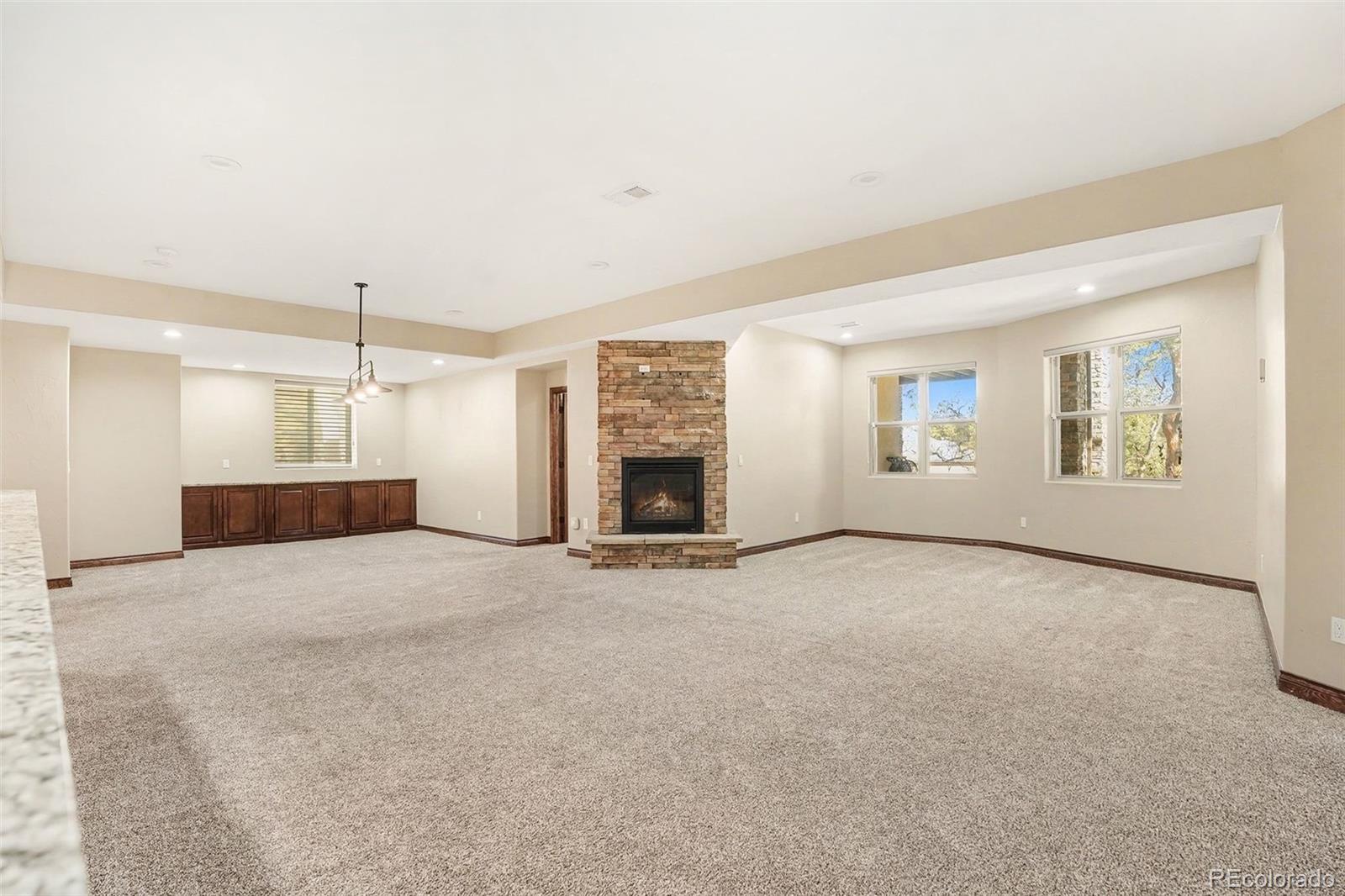 7936 Monarch Road Larkspur, CO 80118 - Photo 18 of 24 an empty room with windows and fireplace