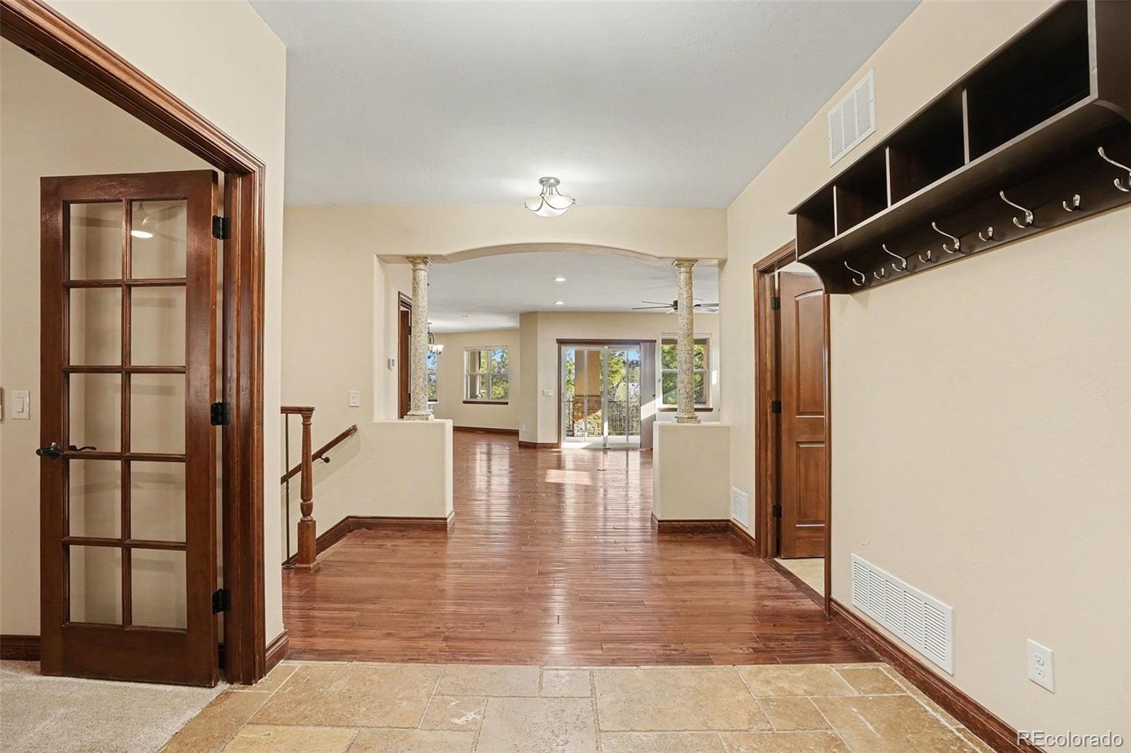 7936 Monarch Road Larkspur, CO 80118 - Photo 3 of 24 a view of a hallway view with wooden floor and staircase