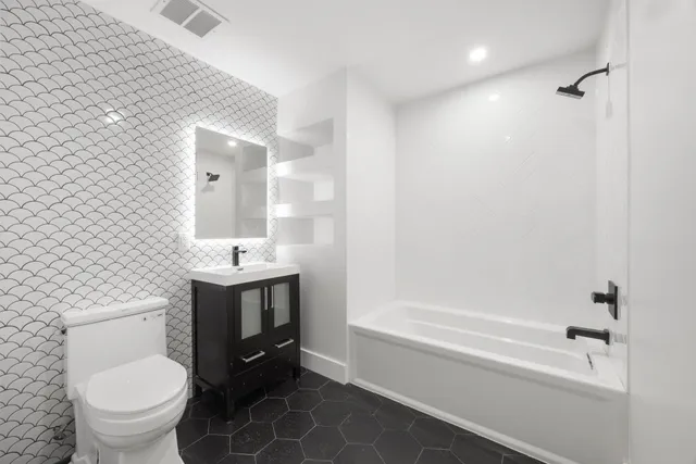 a bathroom with a sink a toilet and shower