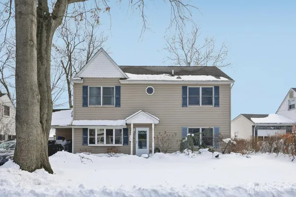 a front view of a house with a yard covered in snow