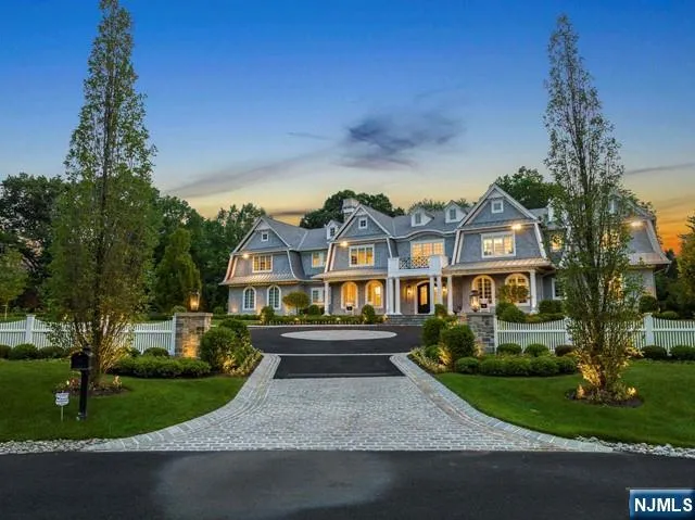 a front view of a house with a garden and tree