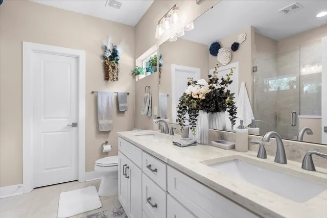 a bathroom with a granite countertop sink a toilet and shower