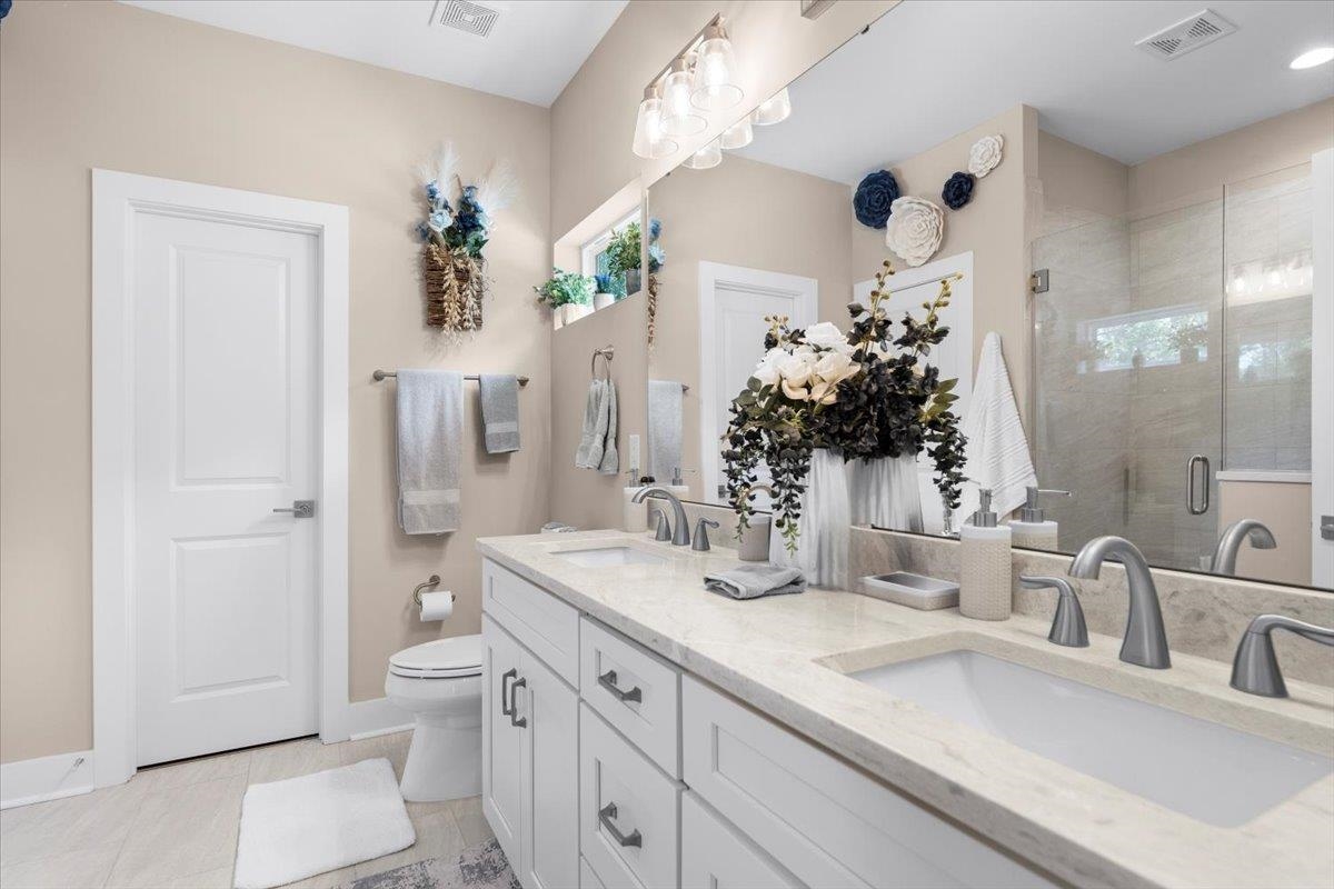 633 West Pope Road St. Augustine, FL 32080 - Photo 20 of 43 a bathroom with a granite countertop sink a toilet and shower