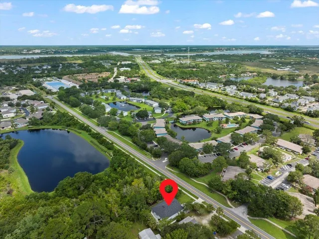 an aerial view of residential houses with outdoor space and trees