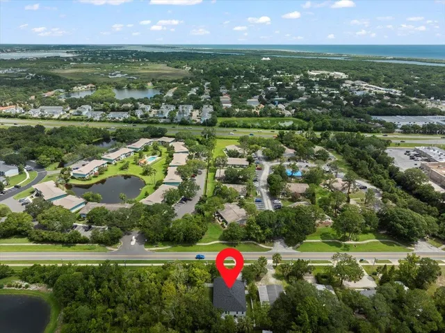 an aerial view of residential houses with outdoor space and lake view