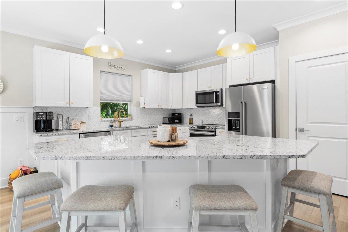 633 West Pope Road St. Augustine, FL 32080 - Photo 6 of 43 a kitchen with stainless steel appliances granite countertop a sink a stove a refrigerator a dining table and chairs with wooden floor