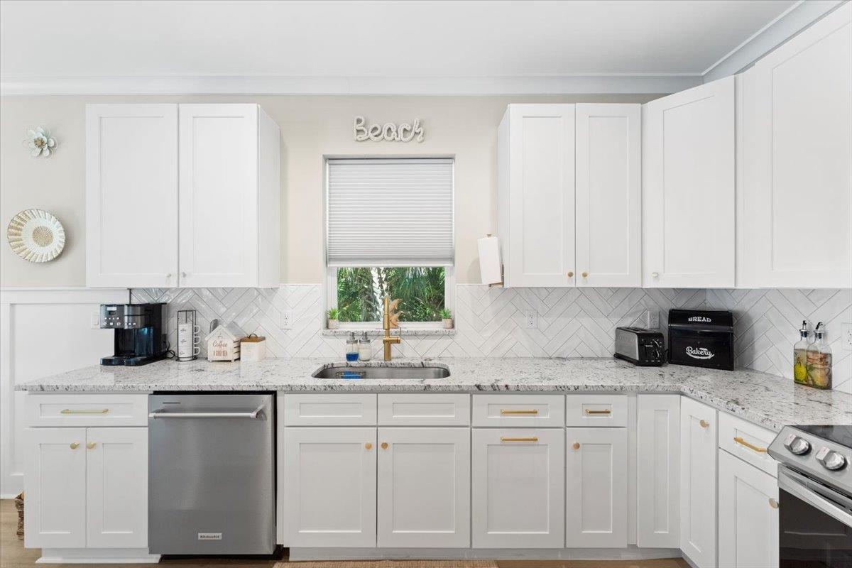 633 West Pope Road St. Augustine, FL 32080 - Photo 8 of 43 a kitchen with granite countertop white cabinets and white appliances